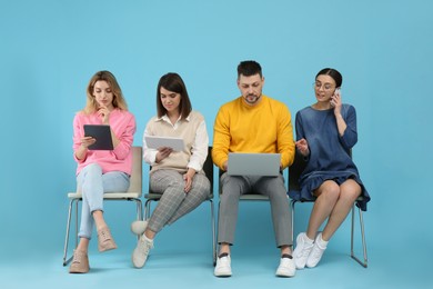 Photo of People waiting for job interview on light blue background