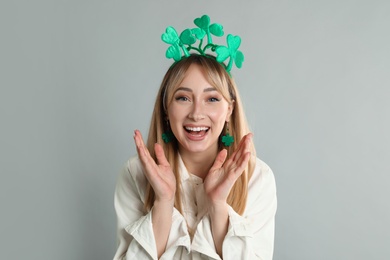 Photo of Happy woman in St Patrick's Day outfit on light grey background