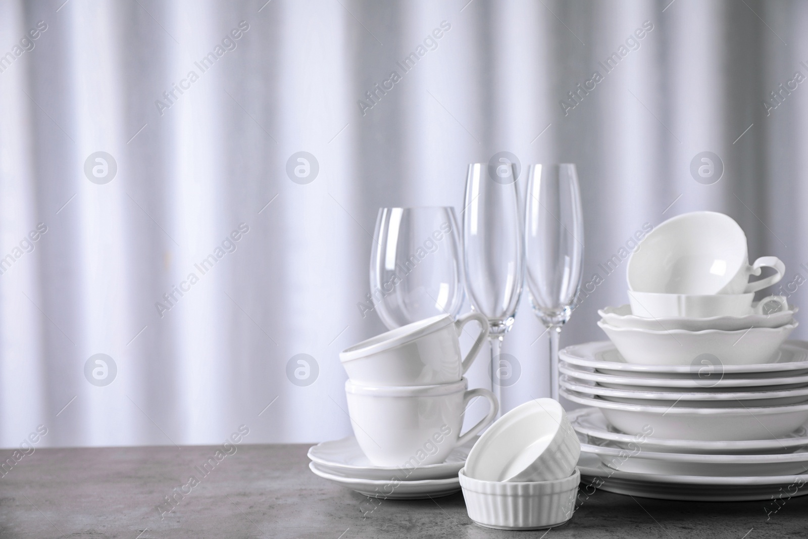 Photo of Set of clean dishware on grey table