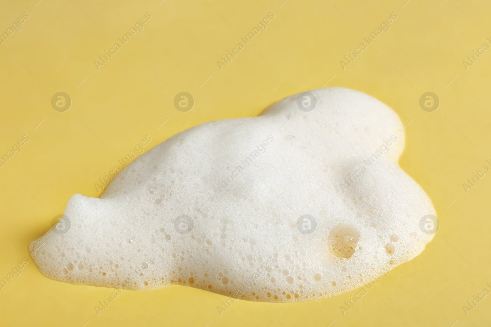 Photo of Drop of soap foam on color background