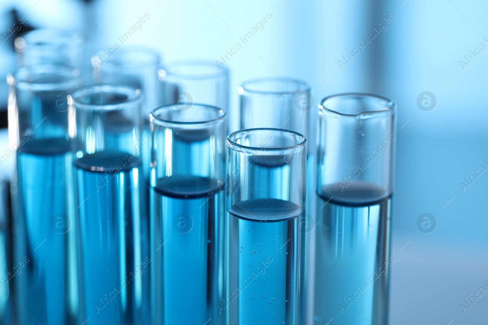 Photo of Test tubes with light blue liquid in laboratory, closeup