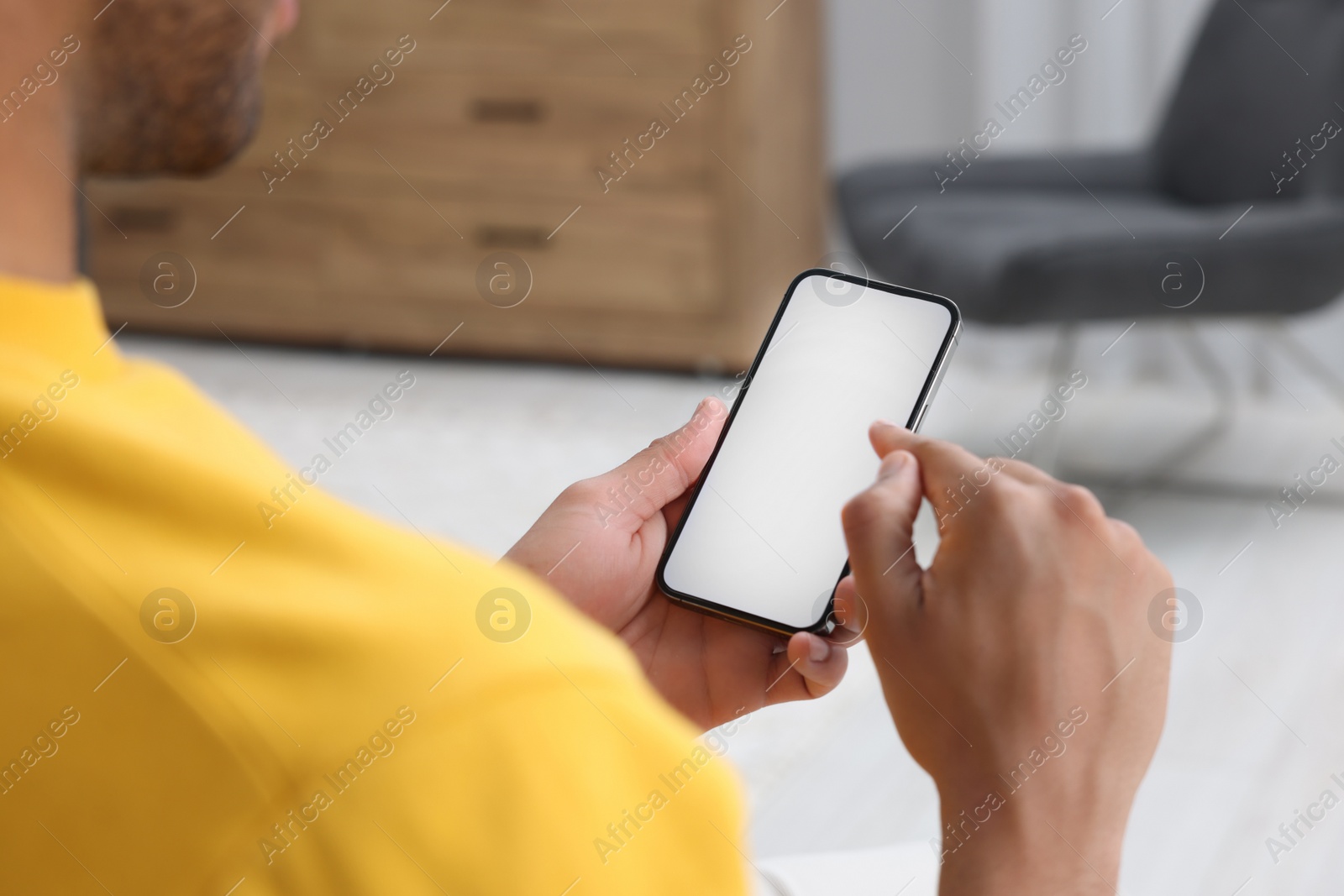 Photo of Man using modern mobile phone indoors, closeup