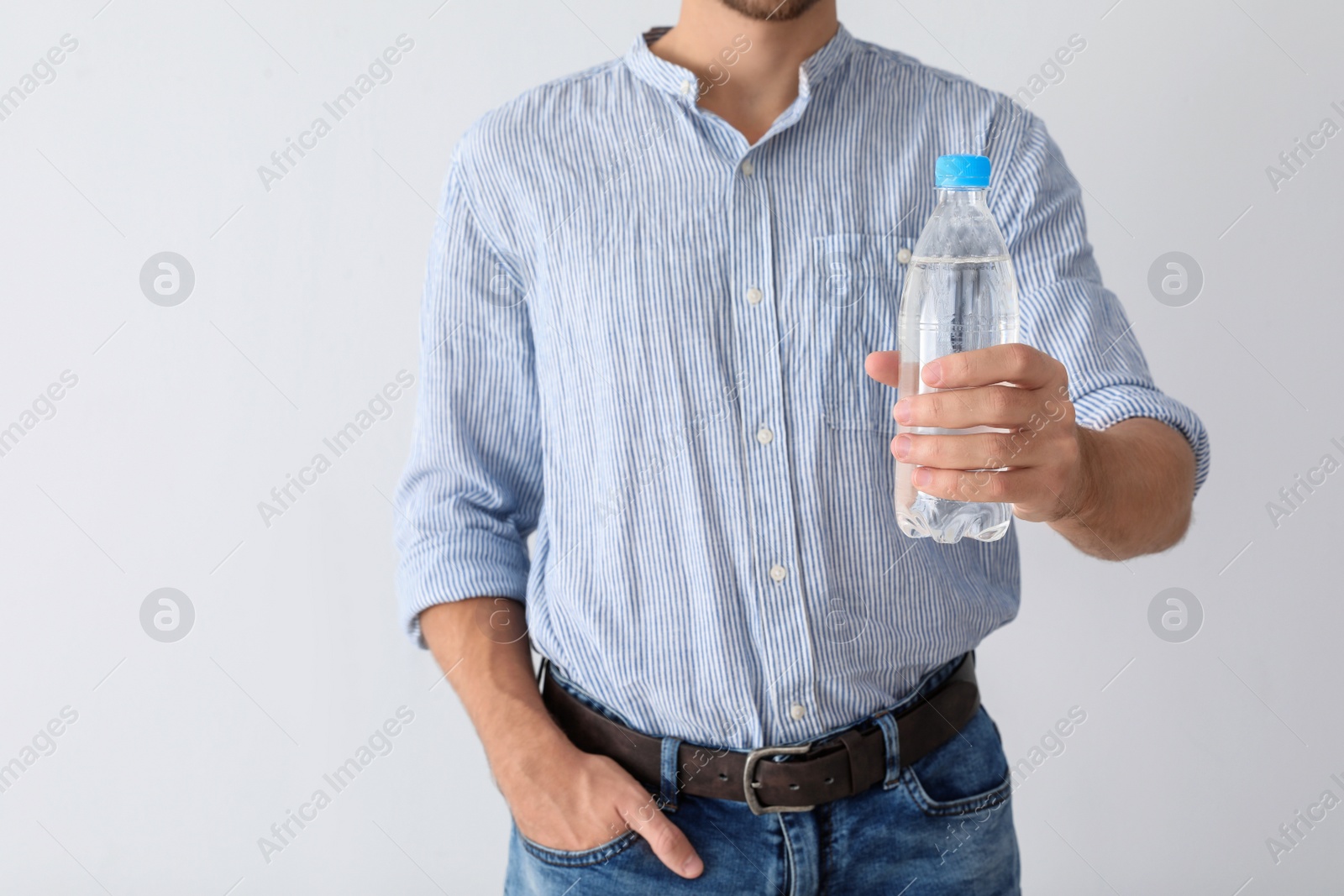 Photo of Man holding bottle of pure water on white background, closeup