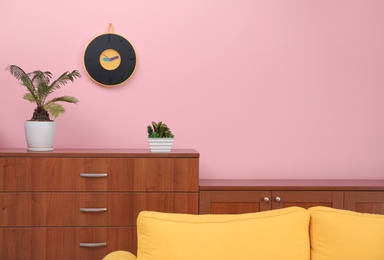 Room interior with stylish clock on wall. Time of day