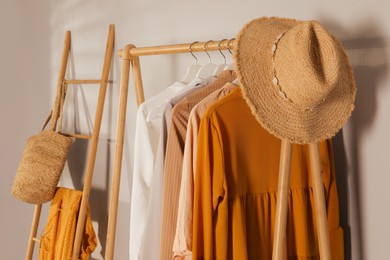 Modern dressing room interior with rack of stylish clothes and hat