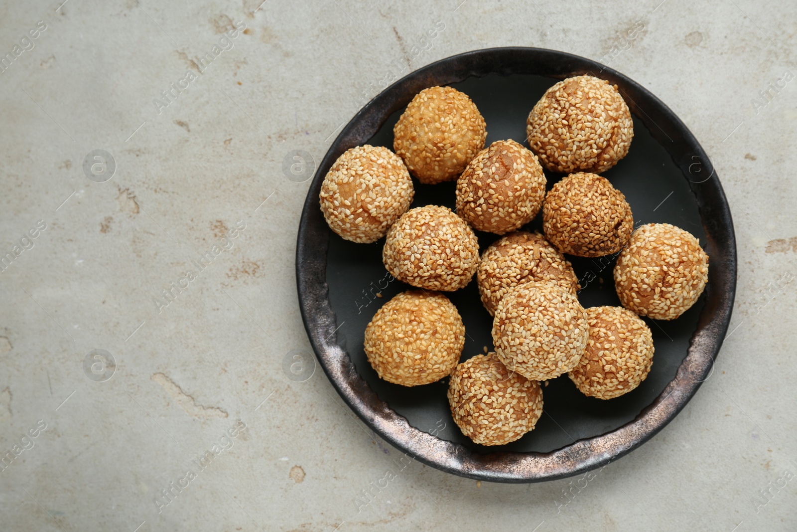 Photo of Delicious sesame balls on light grey textured table, top view. Space for text