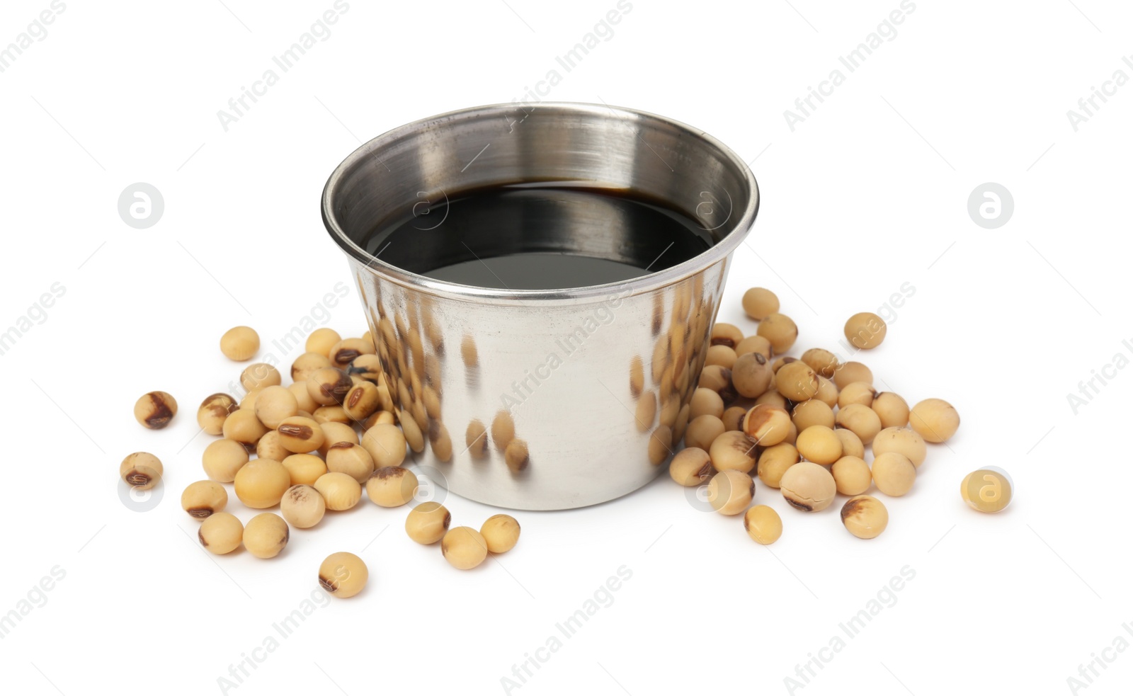 Photo of Tasty soy sauce in bowl and soybeans isolated on white