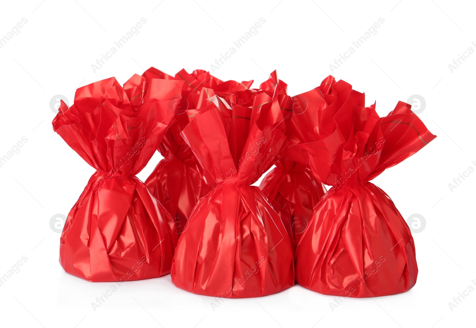 Photo of Delicious candies in red wrappers on white background