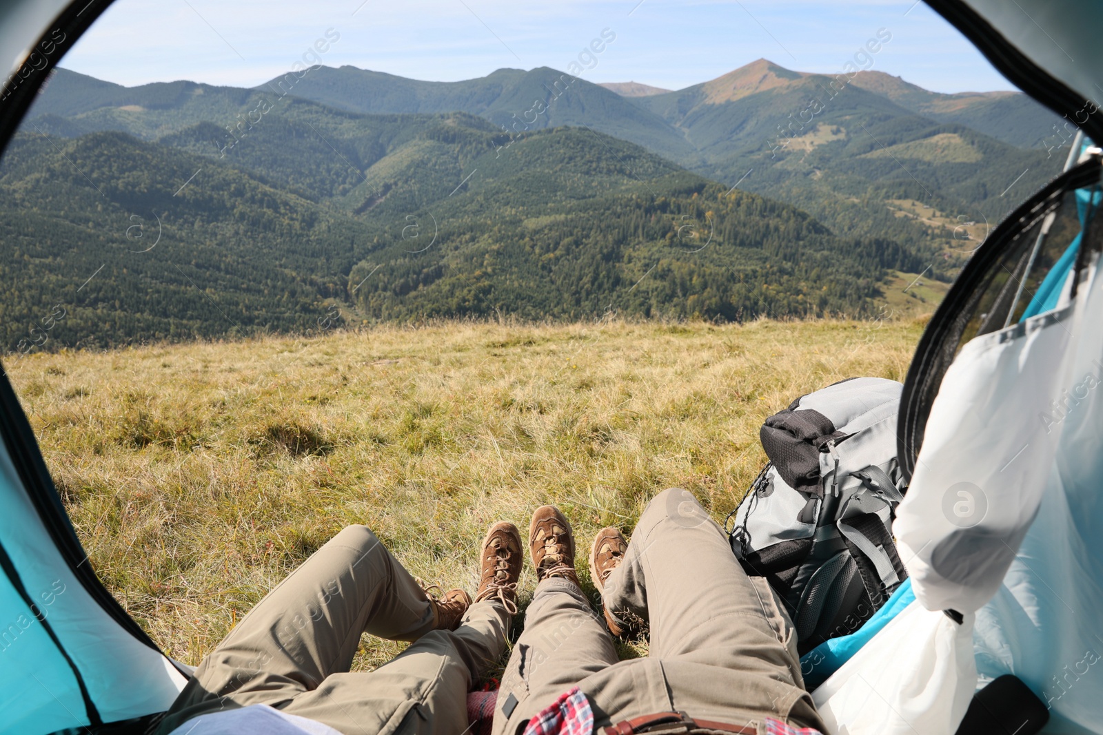 Photo of Couple resting inside of camping tent in mountains, closeup