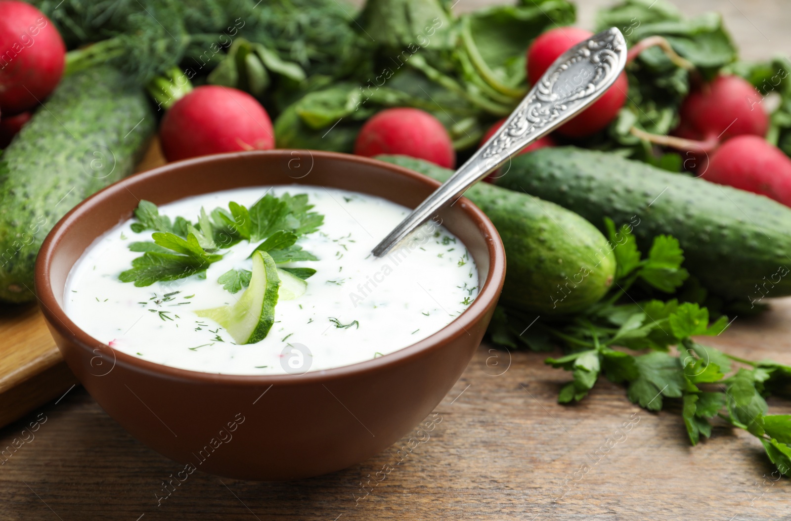 Photo of Delicious cold summer soup with kefir served on wooden table