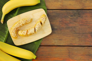 Photo of Delicious fresh and fried bananas on wooden table, flat lay. Space for text