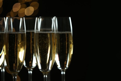 Glasses of champagne on blurred background, closeup. Space for text