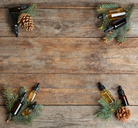 Photo of Flat lay composition with bottles of conifer essential oil and space for text on wooden background