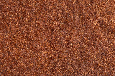 Heap of dry rooibos tea leaves as background, top view