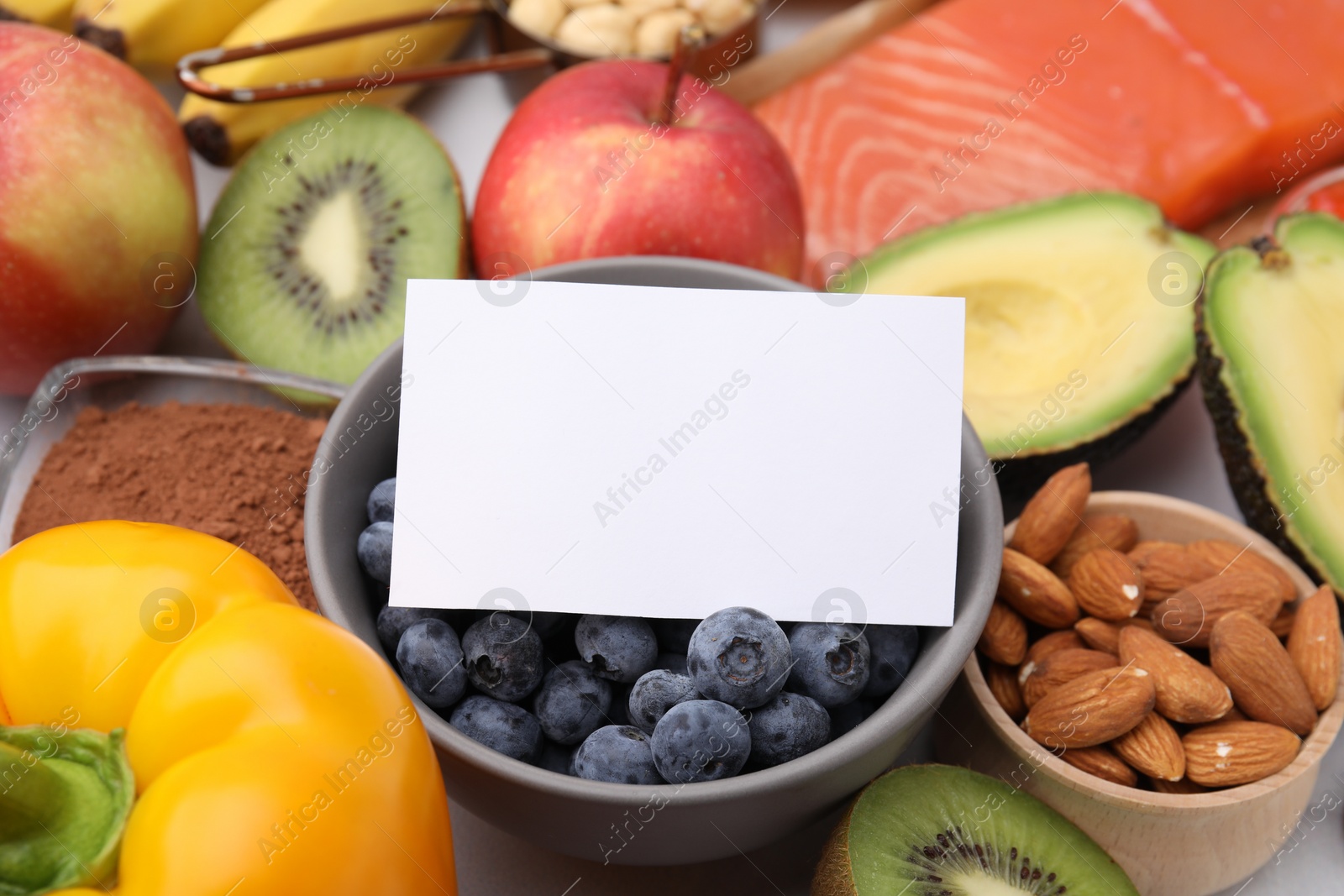 Photo of Many different products and blank card on white table, space for text. Natural sources of serotonin