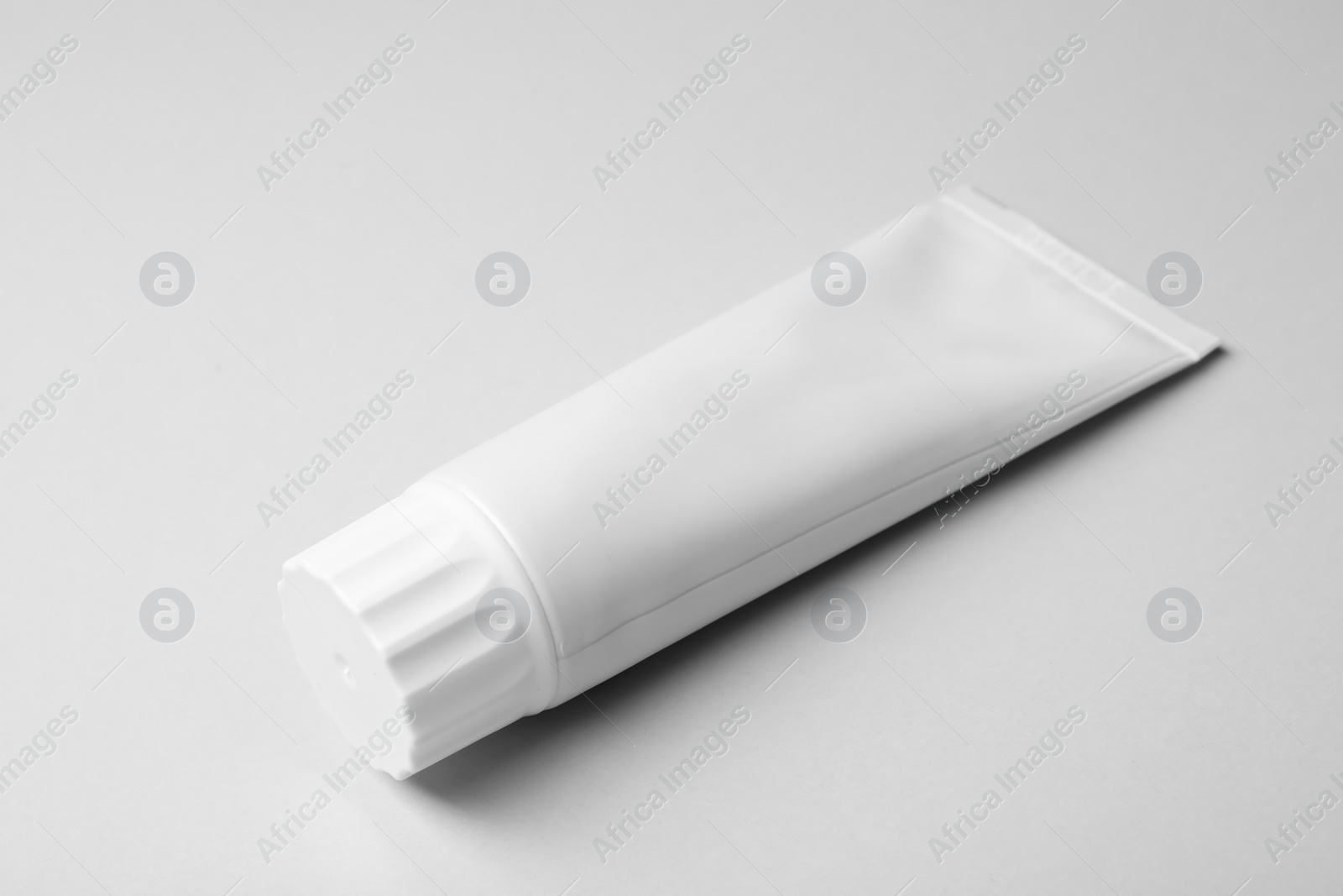 Photo of Blank tube of toothpaste on white background