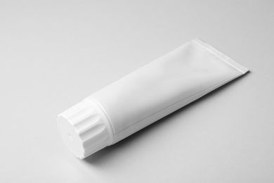 Photo of Blank tube of toothpaste on white background