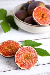 Fresh ripe figs on white wooden table