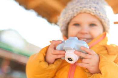 Photo of Cute little photographer outdoors, focus on hands with camera