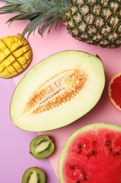 Flat lay composition with melon and other fruits on color background