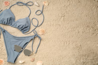 Photo of Flat lay composition with stylish bikini on sand. Space for text