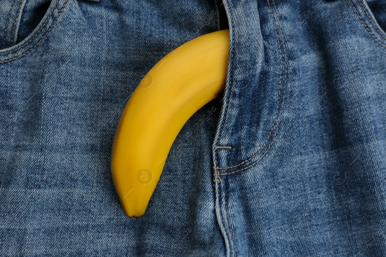 Photo of Jeans with banana in fly symbolizing male sexual organ as background, closeup. Potency problem concept