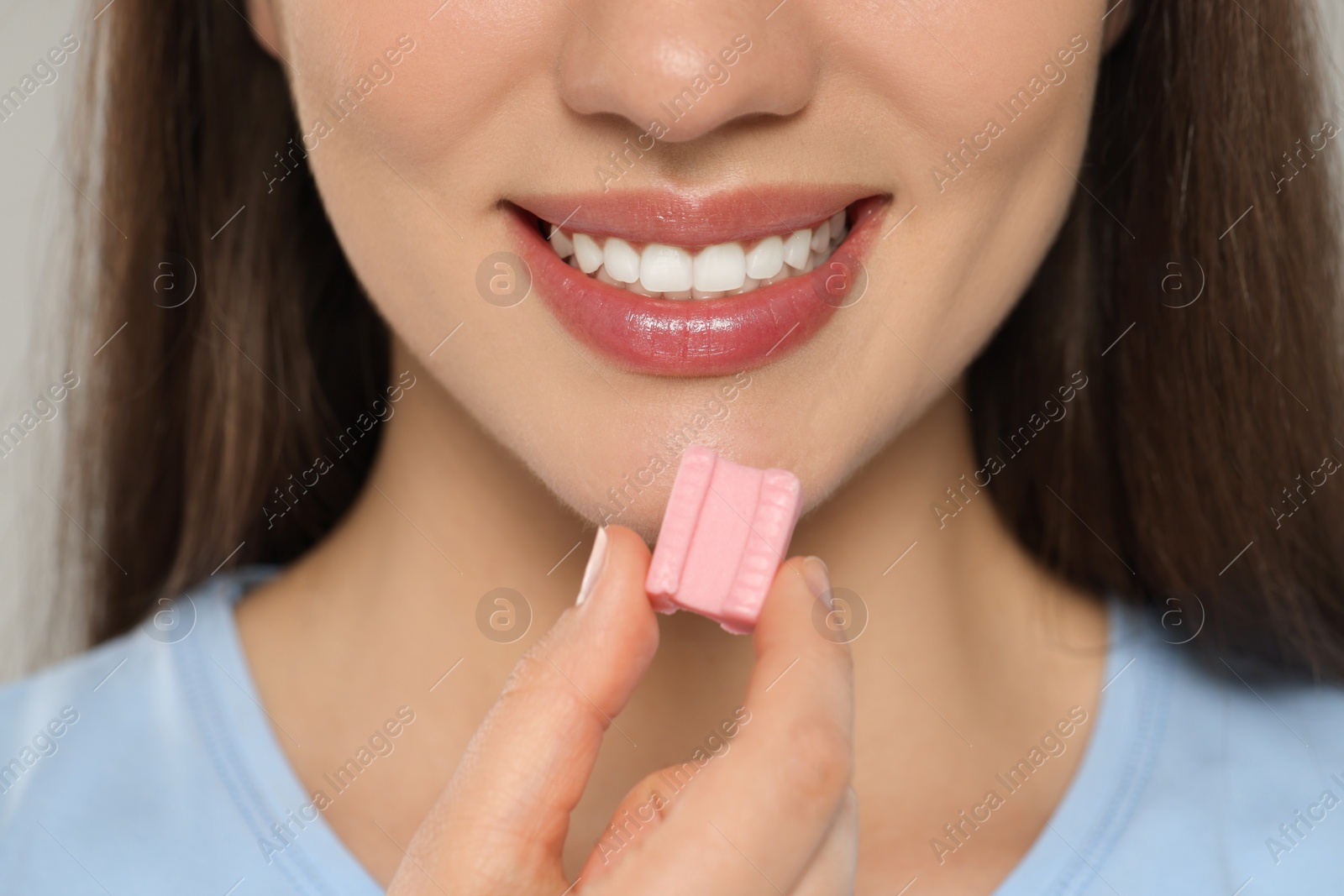 Photo of Woman with chewing gum on grey background, closeup