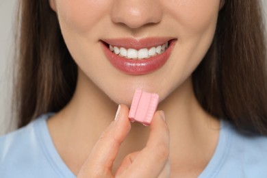 Photo of Woman with chewing gum on grey background, closeup