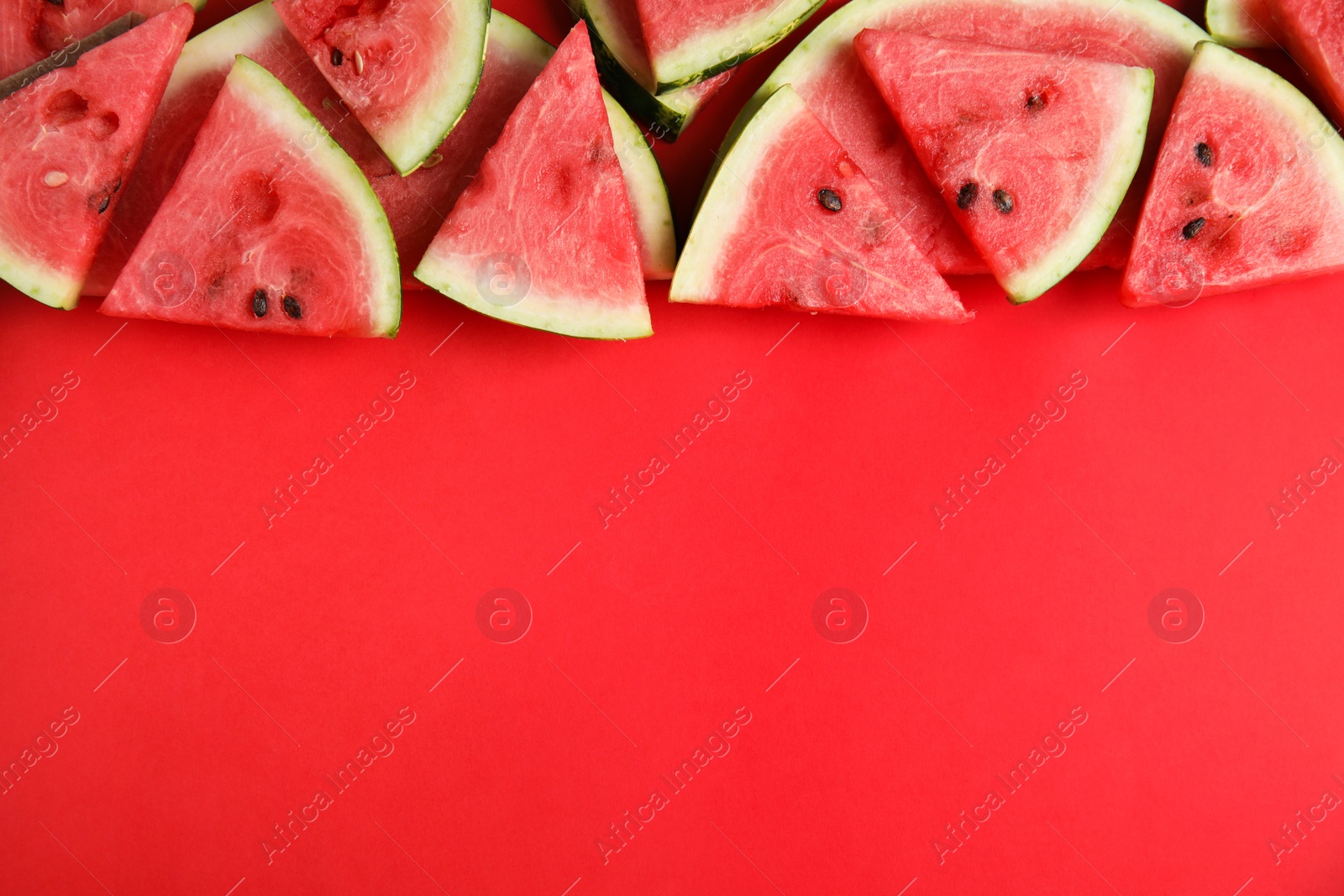 Photo of Slices of ripe watermelon on red background, flat lay. Space for text