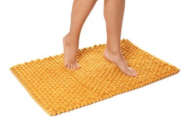Photo of Woman standing on soft orange bath mat against white background, closeup