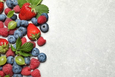 Photo of Mix of fresh berries on light table, flat lay. Space for text