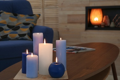 Burning candles on table in living room