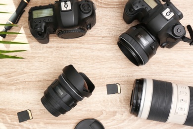 Professional photographer's equipment on wooden table, top view