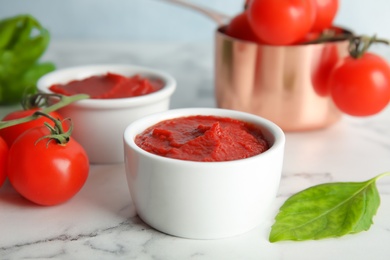 Composition with tomato sauce in bowls on table