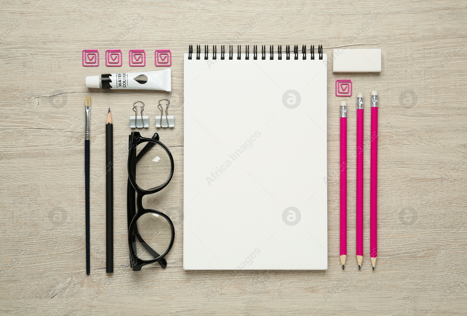 Photo of Flat lay composition with blank sketchbook on wooden table. Space for text