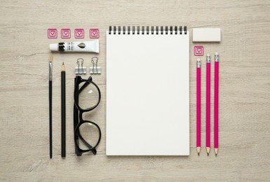Photo of Flat lay composition with blank sketchbook on wooden table. Space for text