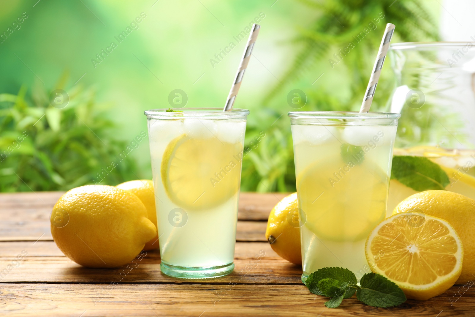 Photo of Natural lemonade with mint on wooden table. Summer refreshing drink