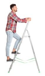 Young handsome man climbing up metal ladder on white background