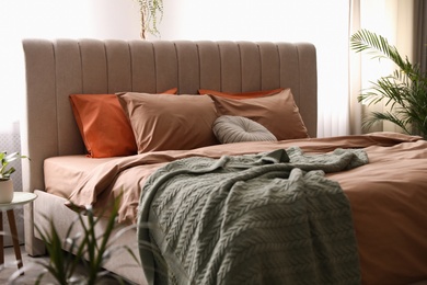 Photo of Bed with stylish cotton linens in room