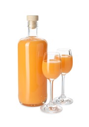 Photo of Bottle and glasses with tasty tangerine liqueur isolated on white
