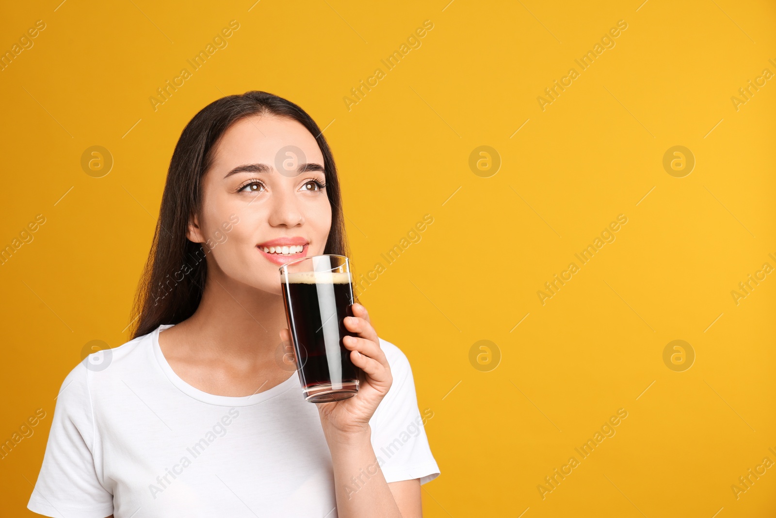 Photo of Beautiful woman with cold kvass on yellow background. Traditional Russian summer drink