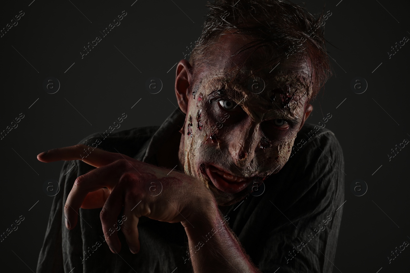 Photo of Scary zombie on dark background. Halloween monster