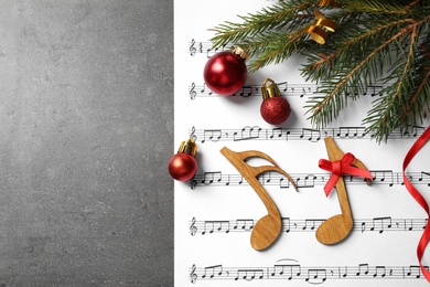 Christmas decorations, notes and music sheet on grey stone table, flat lay with space for text
