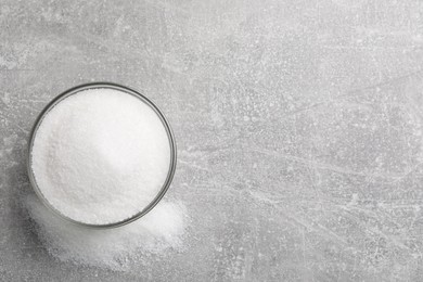 Granulated sugar on light grey table, top view. Space for text