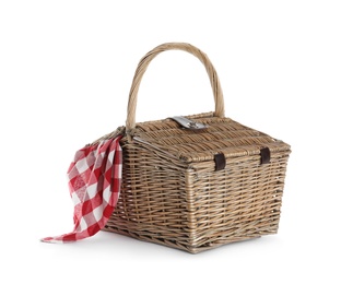 Closed wicker picnic basket with checkered blanket on white background