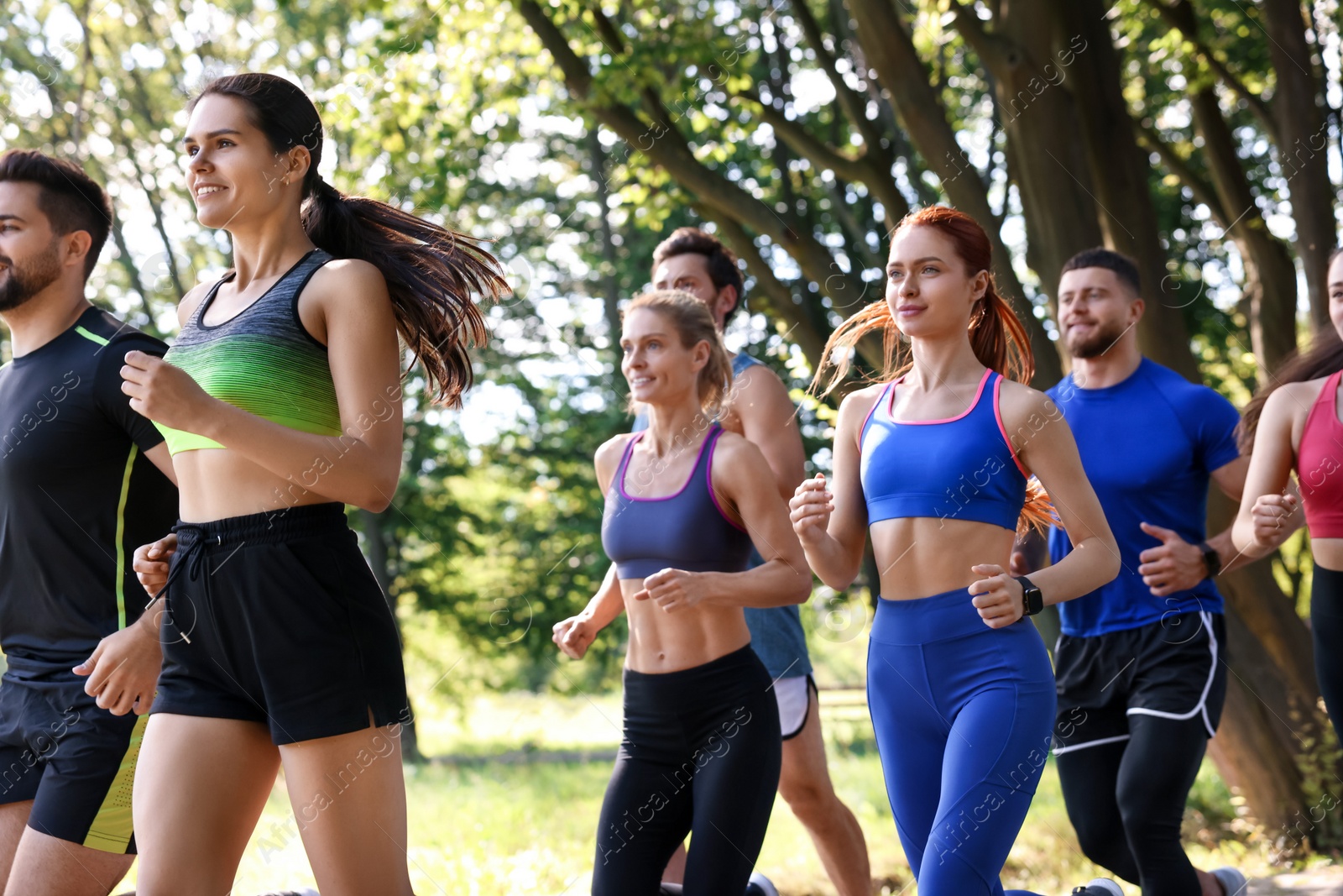 Photo of Group of people running in park on sunny day