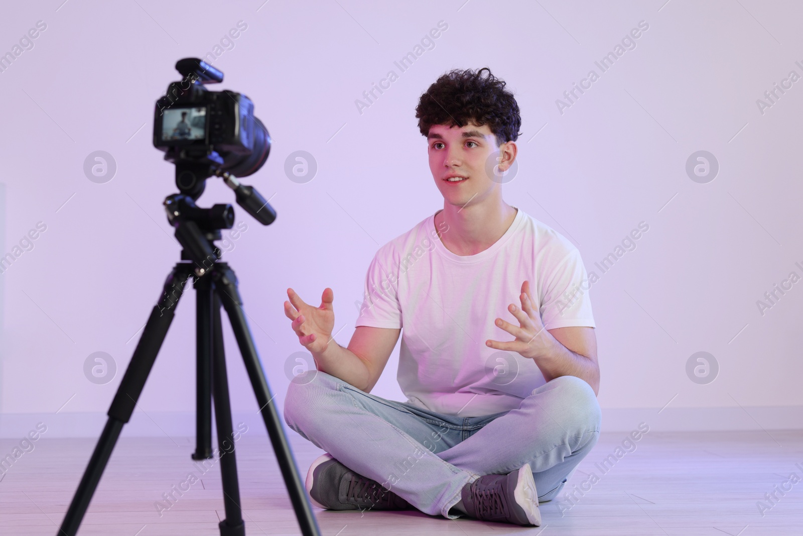 Photo of Teenage blogger explaining something while streaming indoors