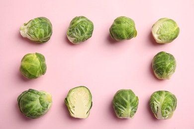 Fresh Brussels sprouts on pink background, flat lay. Space for text