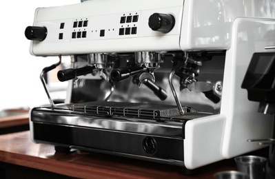 Photo of Modern coffee machine on bar counter in cafe