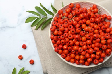 Fresh ripe rowan berries and leaves on white marble table, flat lay